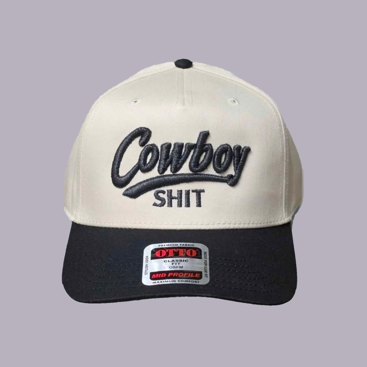 Cowboy Shit Embroidered Hat — Cream & Black — product view on grey-purple background
