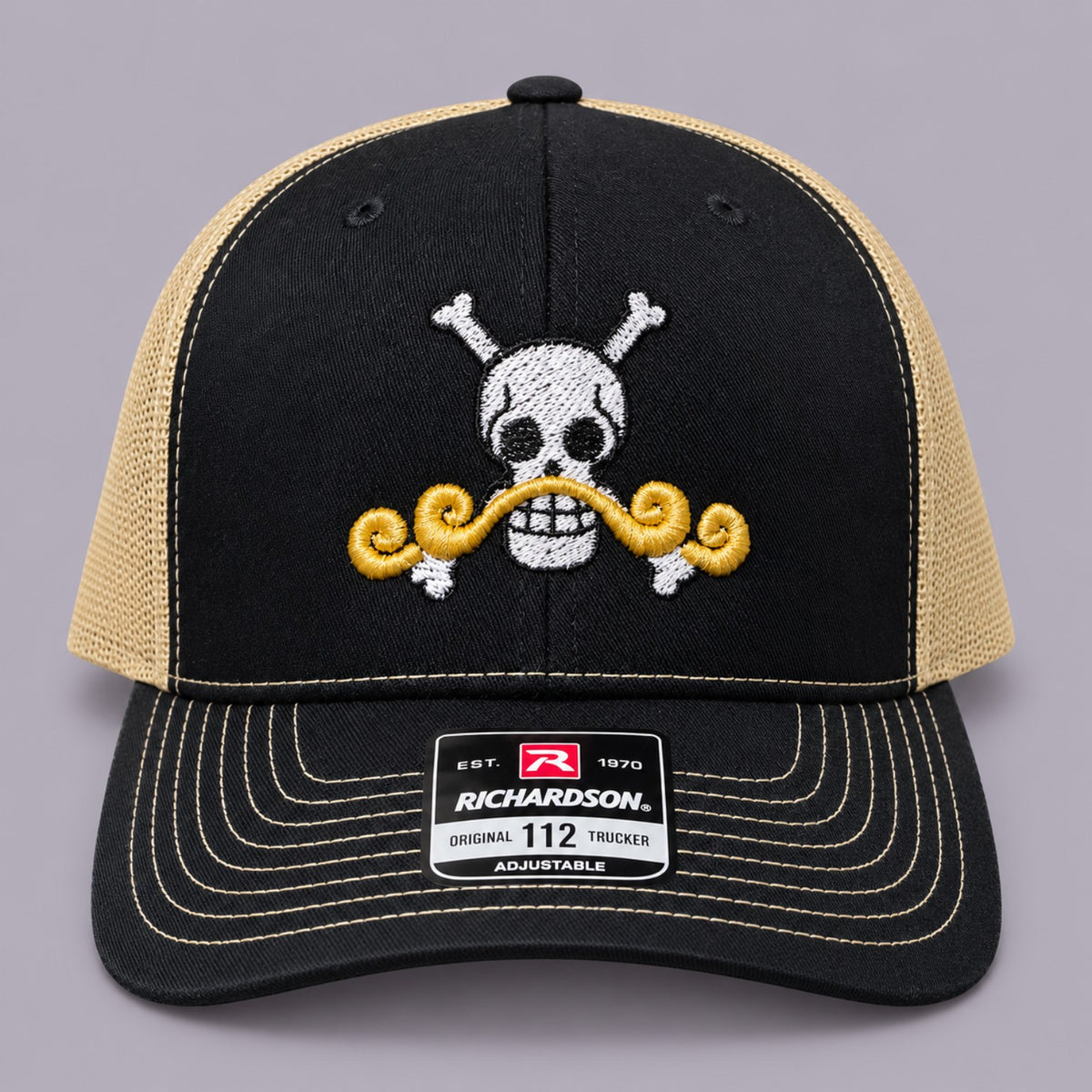 Front of black and Vegas gold Richardson 112 hat with white pirate skull and gold moustache embroidery
