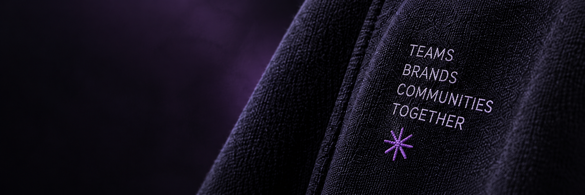 Teams, brands, communities, together embroidered on black fabric with a purple stitched star