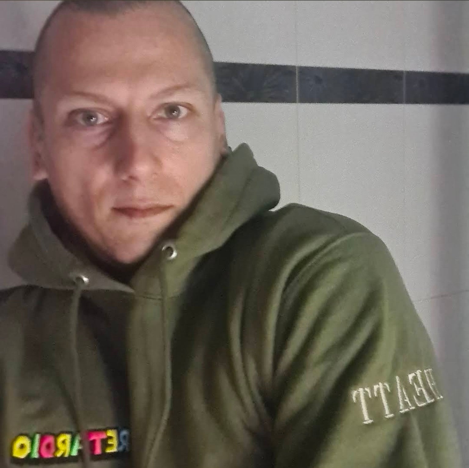 Theta wearing his custom green embroidered hoodie